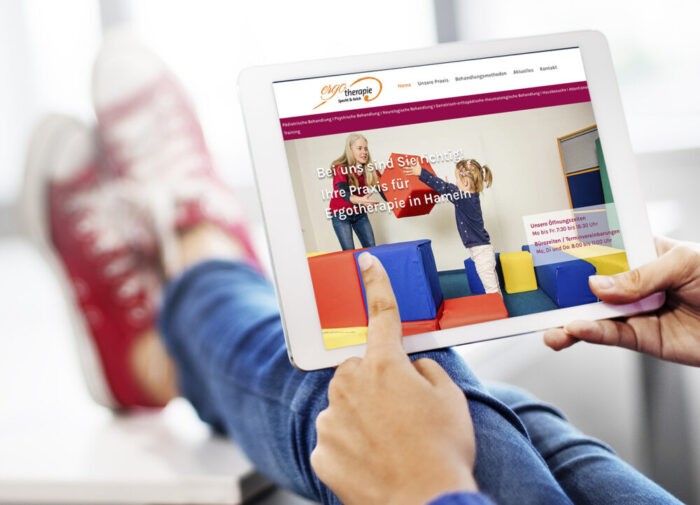 Hands using a mockup tablet with feet up in the background Webdesign Ergotherapiepraxis
